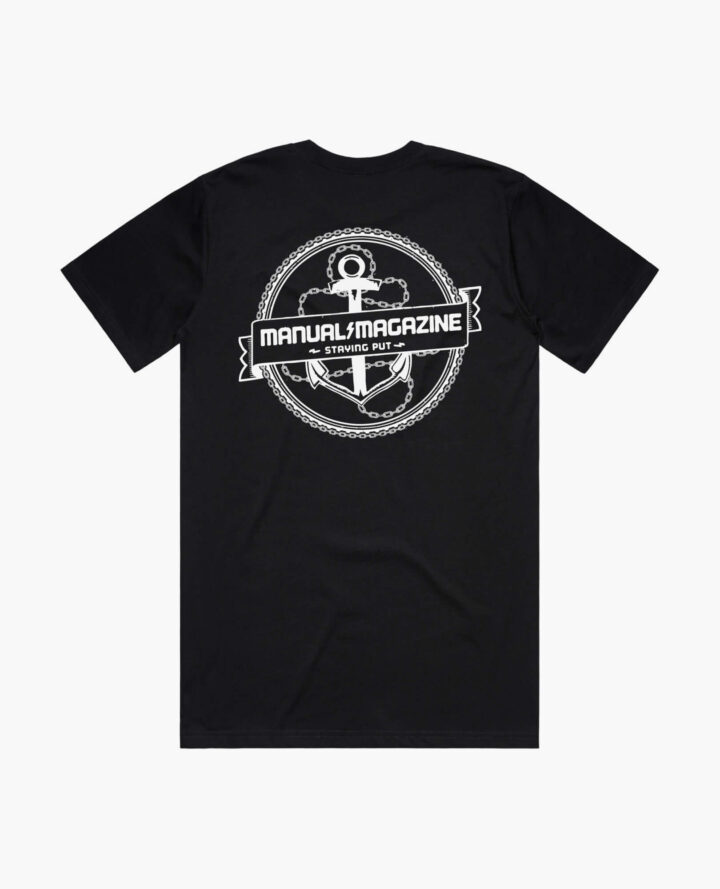 A product photo of the Manual Staying Put t-shirt in black. Showing the back print.