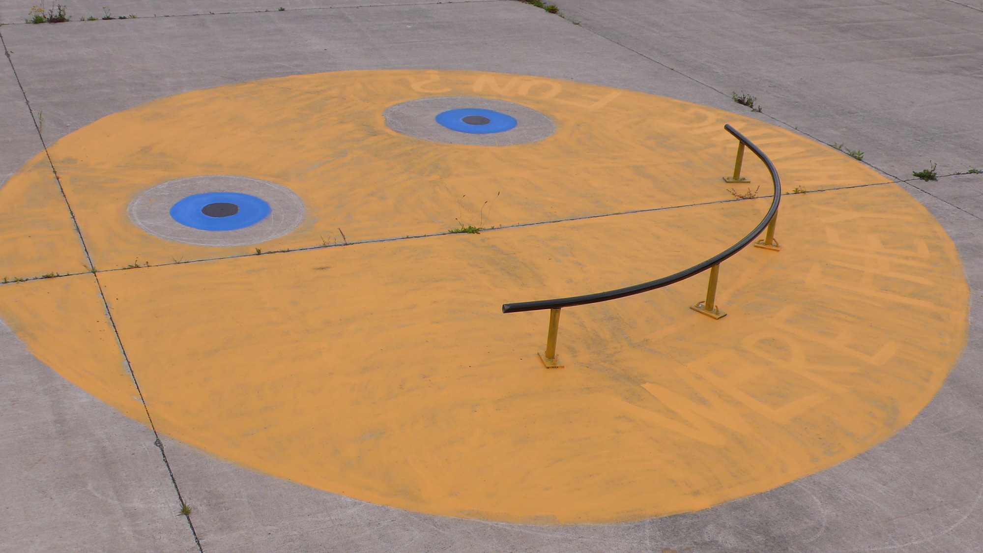 A curved rail design and made for skateboarding positioned on a painted smiley face with the words 'Were they having fun?'