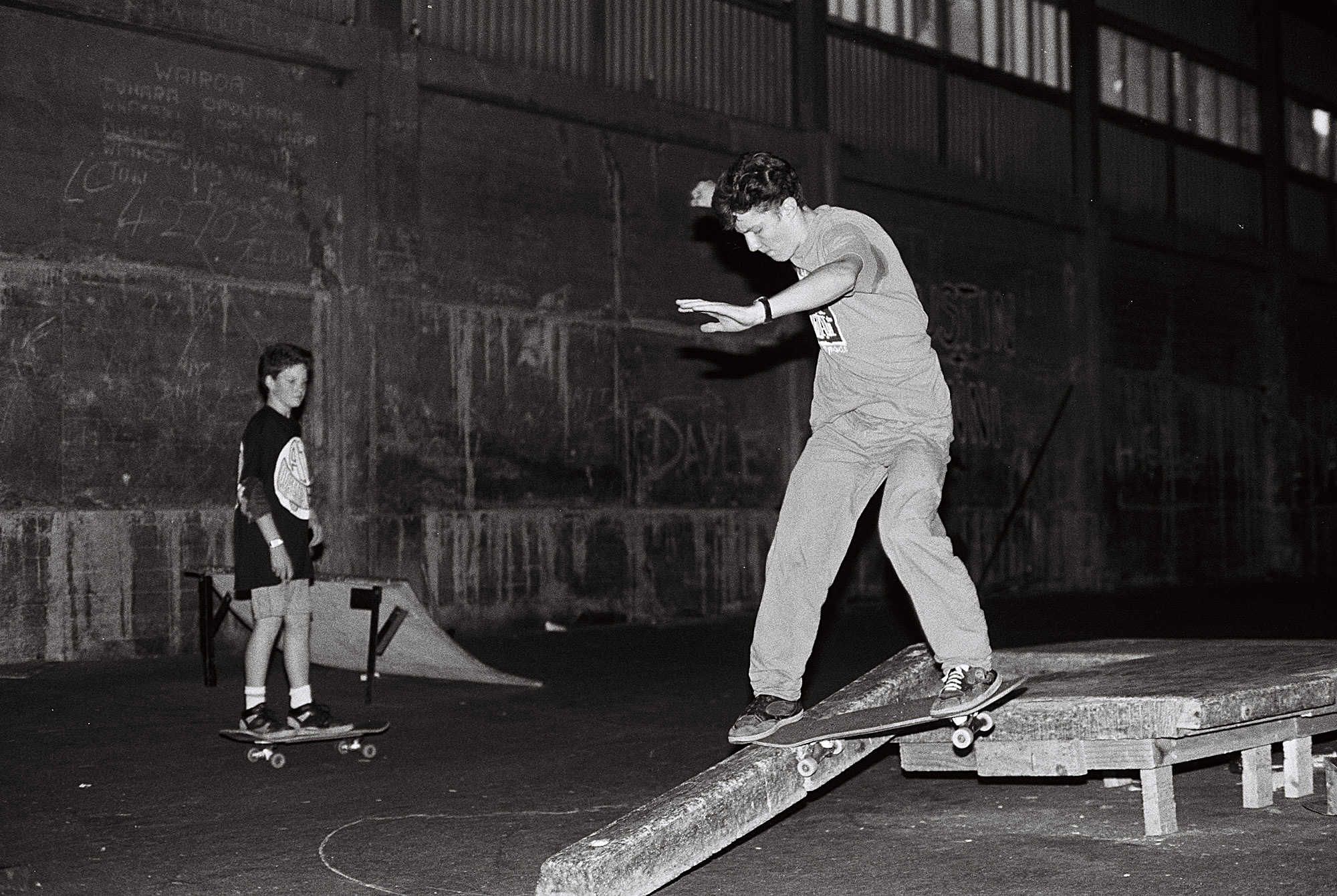 Chris Scott performing a frontside tailslide on a concrete parking block at The Skate Pit in Wellington, 1990.