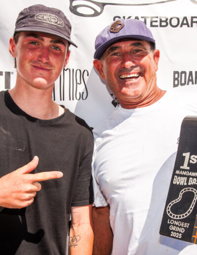 Dave Crabb presents Keefer Wilson with the longest grind award for his frontside 50-50 around the shallow end.