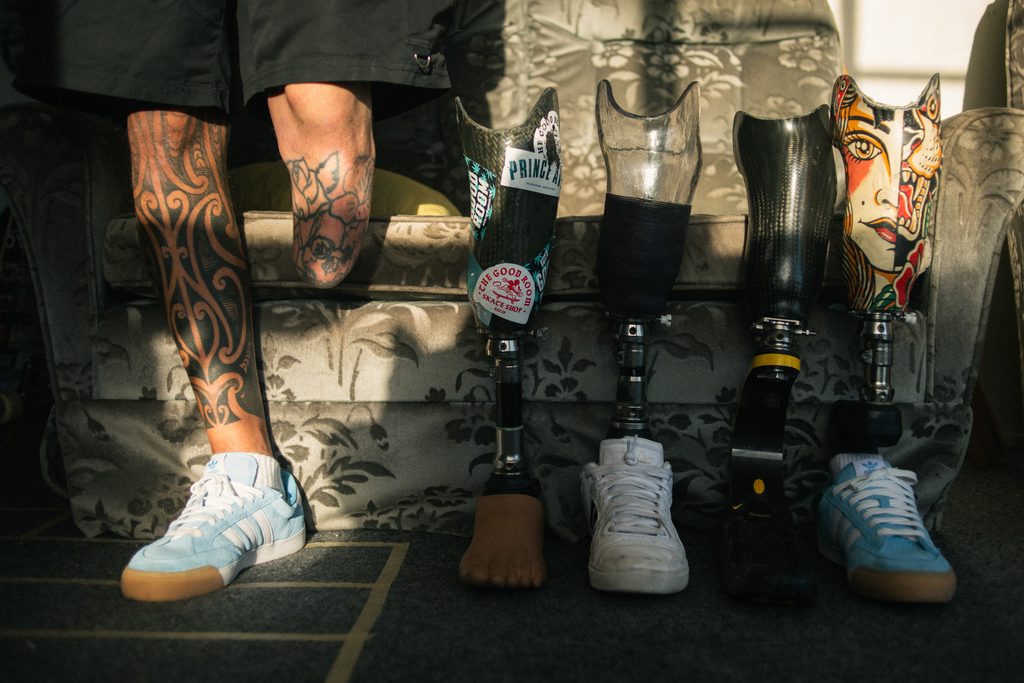 Jayden Daniels in his home with his different prosthetic legs lined up next to him.